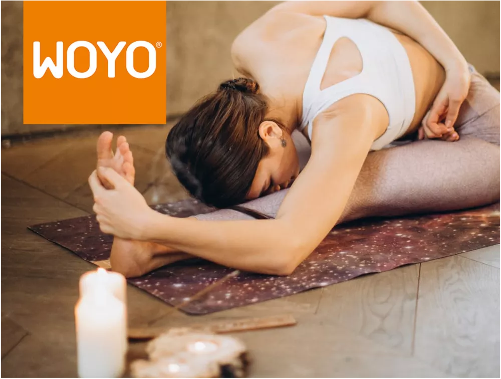 Eine Frau praktiziert eine Yoga-Pose, links oben im Bild das WOYO Logo.